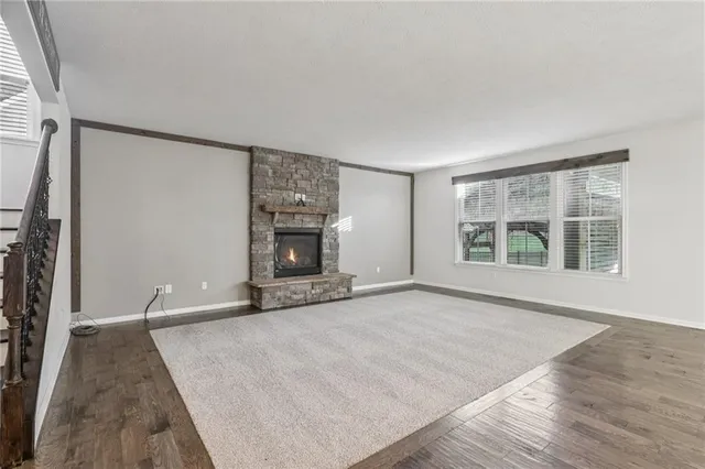 an empty room with windows and fireplace