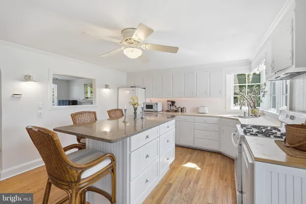 a kitchen with a dining table chairs and white cabinets