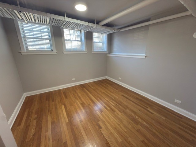 2147 West Lunt Avenue, Unit G Chicago, IL 60645 - Photo 13 of 16 wooden floor in an empty room with a window