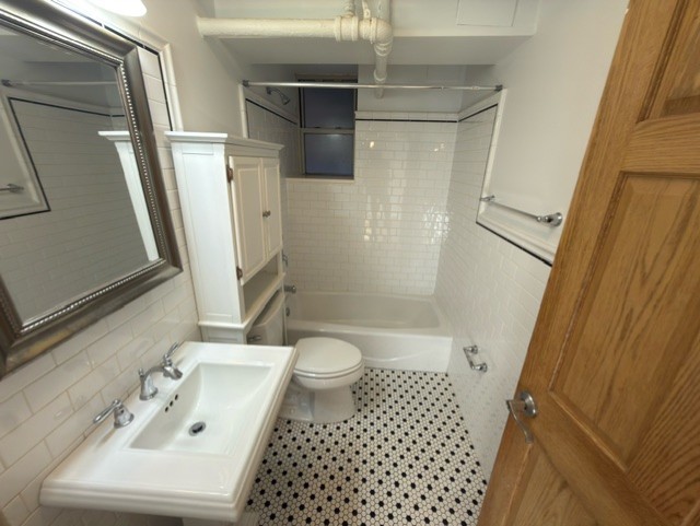 2147 West Lunt Avenue, Unit G Chicago, IL 60645 - Photo 14 of 16 a bathroom with a sink a toilet a shower and a mirror