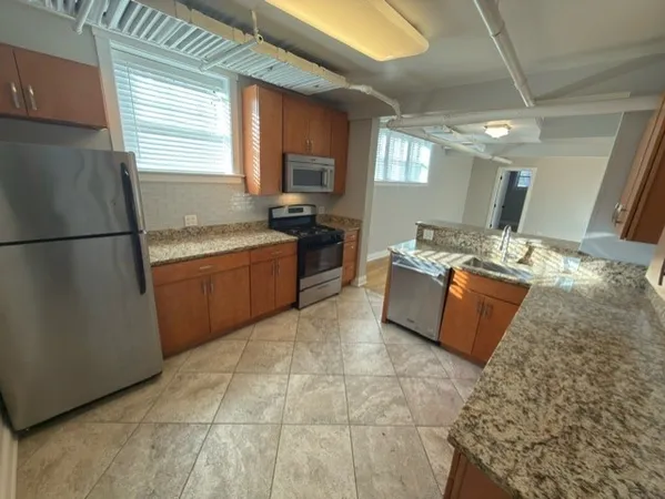 a kitchen with stainless steel appliances granite countertop a sink stove and refrigerator