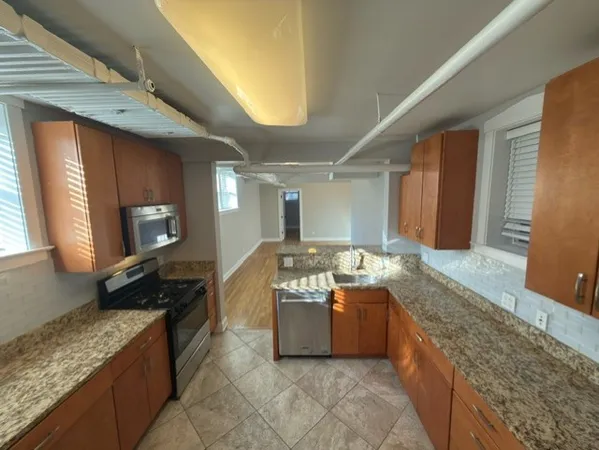a kitchen with stainless steel appliances granite countertop a sink and a wooden cabinets