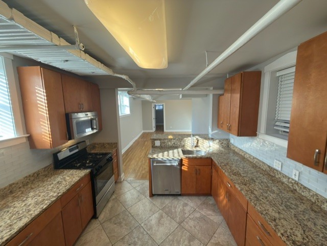 2147 West Lunt Avenue, Unit G Chicago, IL 60645 - Photo 3 of 16 a kitchen with stainless steel appliances granite countertop a sink and a wooden cabinets
