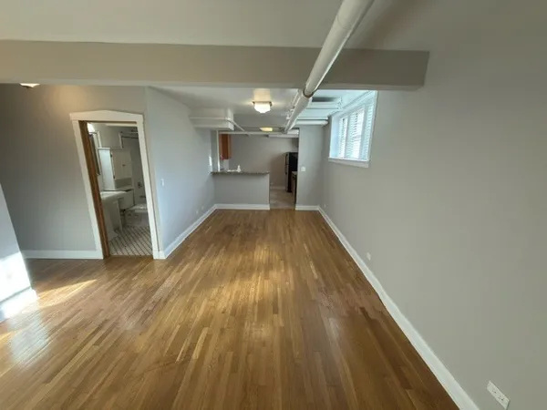 a view of empty room with wooden floor