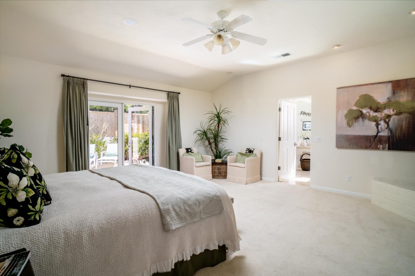 335 El Caminito Road Carmel Valley, CA 93924 - Photo 26 of 59 a spacious bedroom with a bed and a chandelier