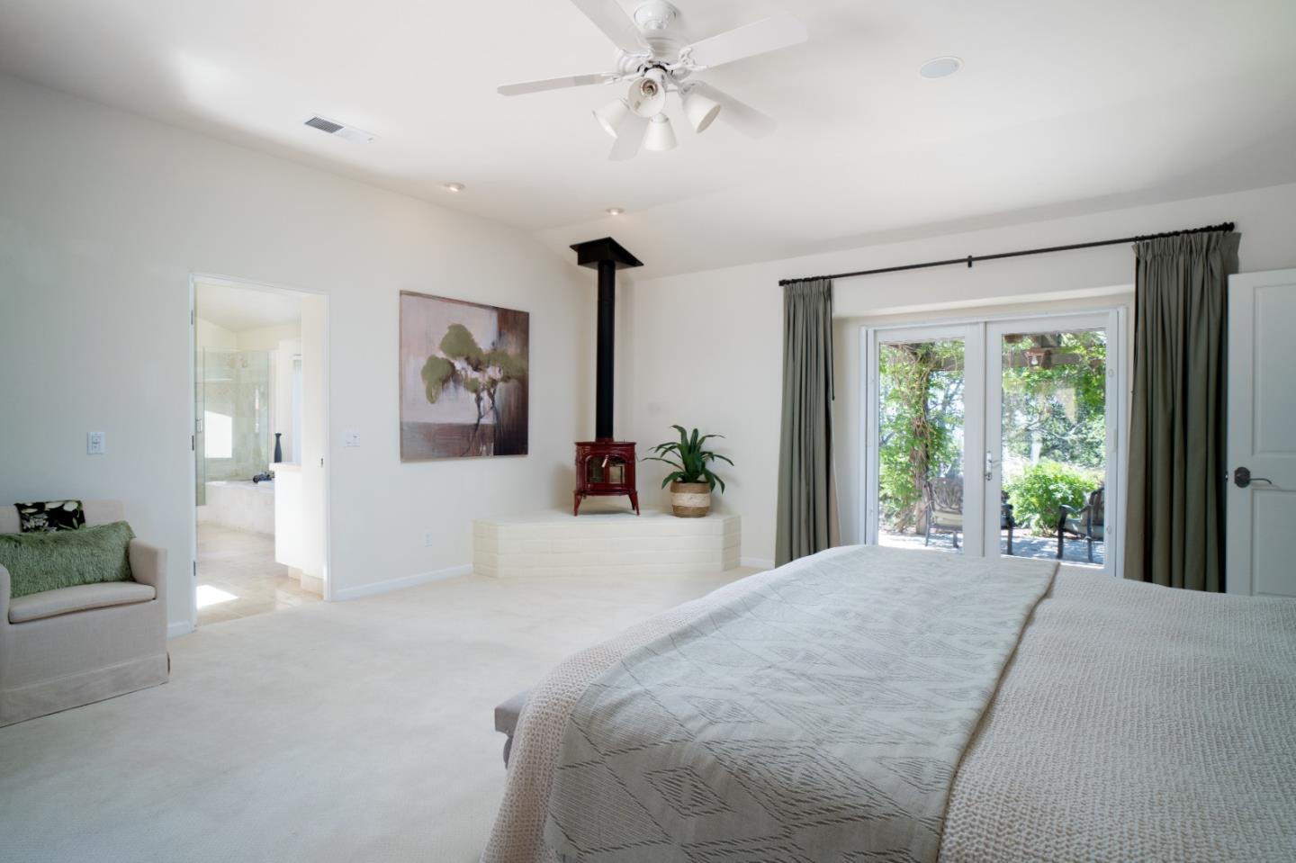 335 El Caminito Road Carmel Valley, CA 93924 - Photo 27 of 59 a bedroom with a large bed and a chandelier