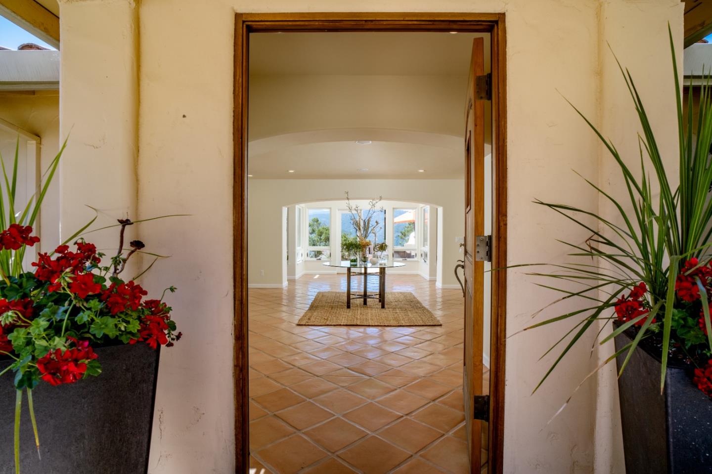 335 El Caminito Road Carmel Valley, CA 93924 - Photo 3 of 59 a vase of flowers sitting on a floor next to a window