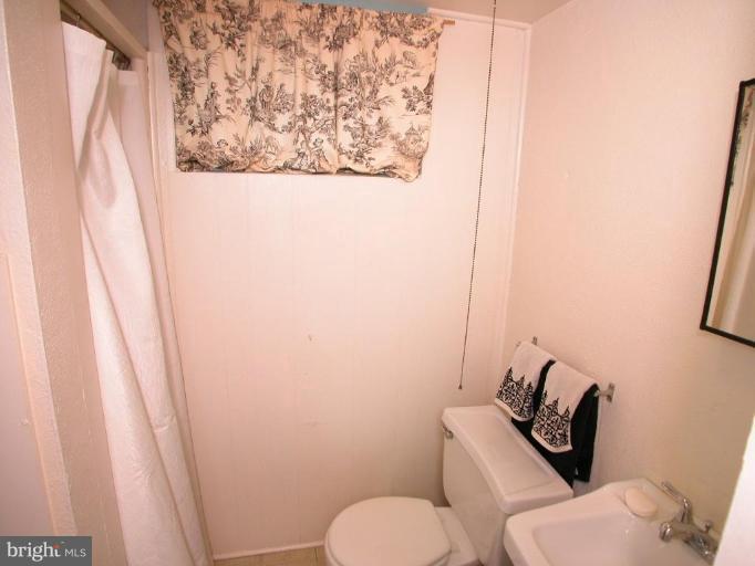 213 Blenheim Road Baltimore, MD 21212 - Photo 13 of 16 a bathroom with a toilet and a shower curtain