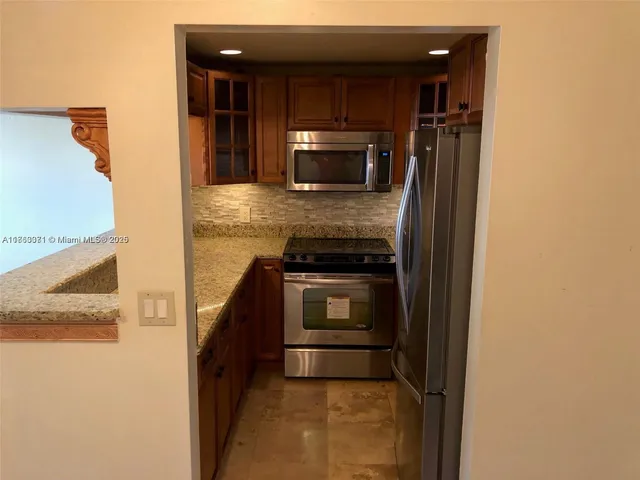 a kitchen with a refrigerator and a stove