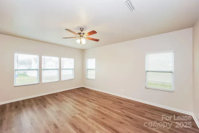 an empty room with a window and a fan