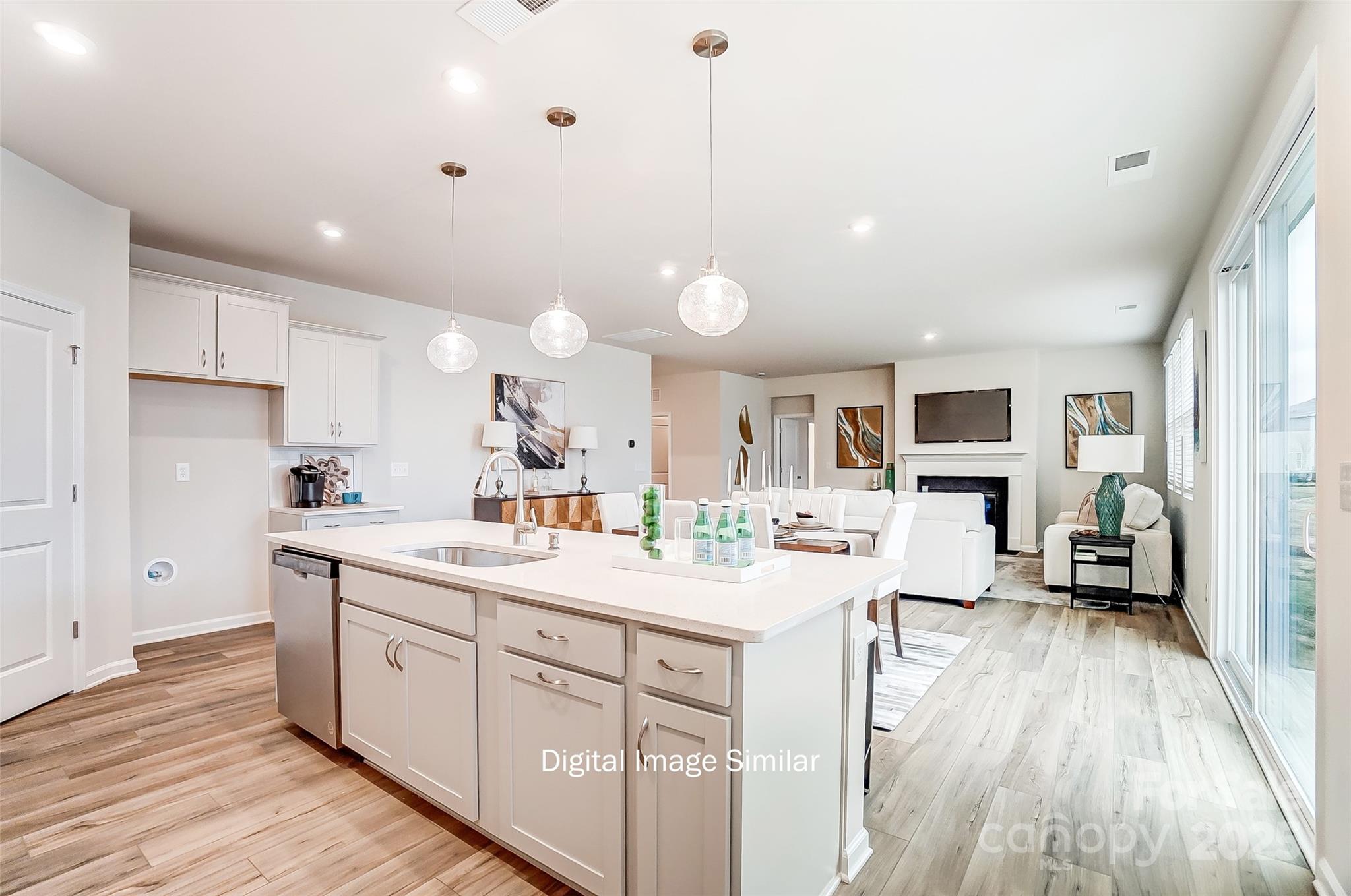 2526 Mabel Lane Monroe, NC 28110 - Photo 22 of 48 a kitchen with a sink a stove a refrigerator and white cabinets with wooden floor
