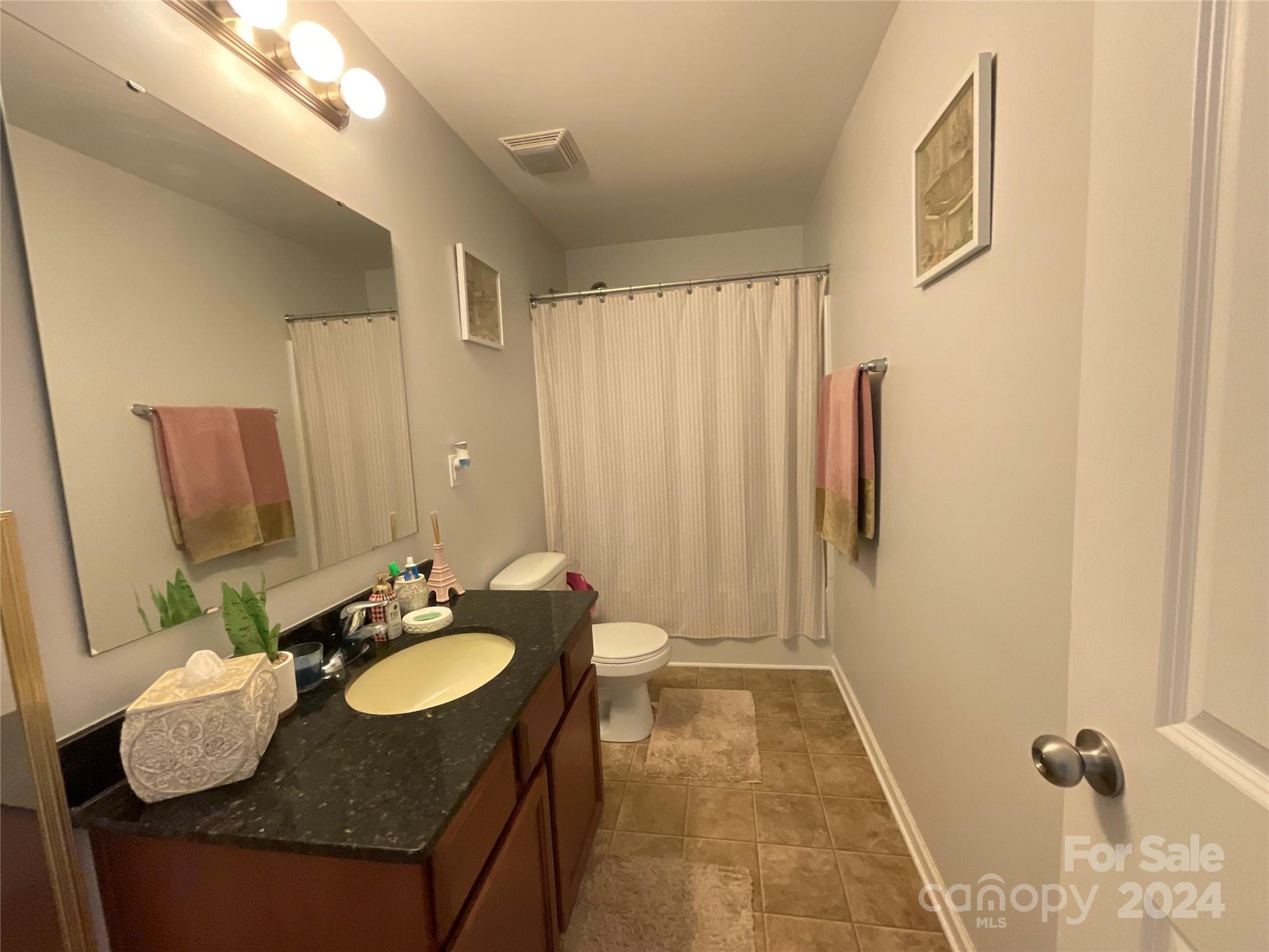 3271 Brickwood Circle Midland, NC 28107 - Photo 11 of 20 a bathroom with a granite countertop sink a mirror and a shower