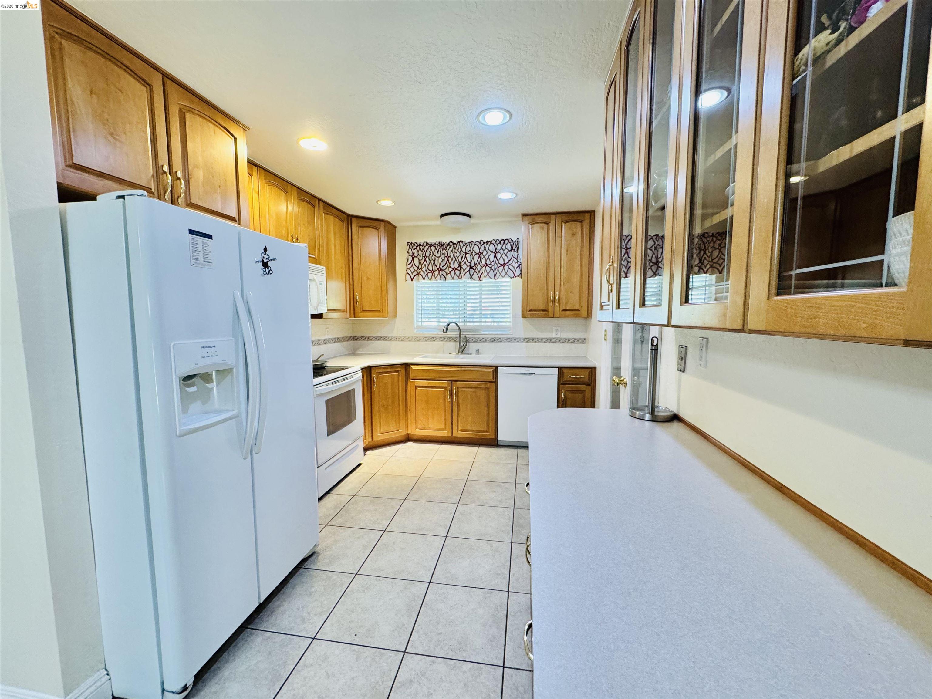 3513 Rio Grande Drive Antioch, CA 94509 - Photo 2 of 22 Kitchen featuring wood cabinetry, solid surface countertops, tile flooring, recessed lighting, and a ceramic tile backsplash