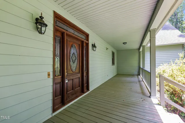 a view of backyard with a wooden deck and floor to ceiling window