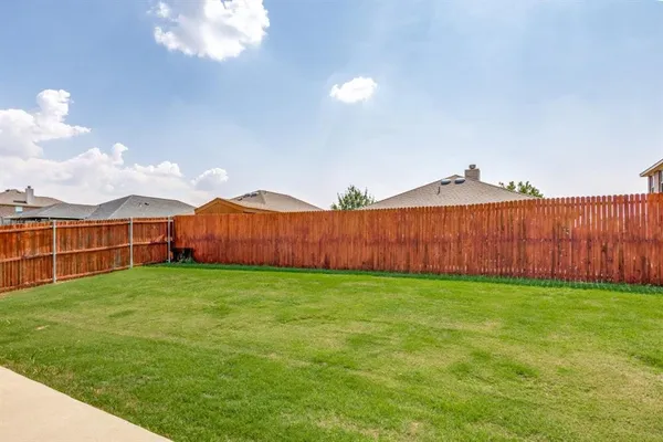 a view of a backyard with wooden fence