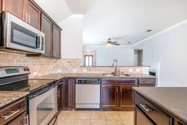 a kitchen with stainless steel appliances granite countertop a sink and stove top oven