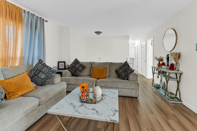 a living room with furniture and a wooden floor