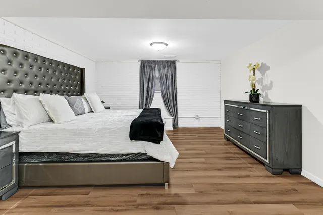 a bedroom with a bed and wooden floor