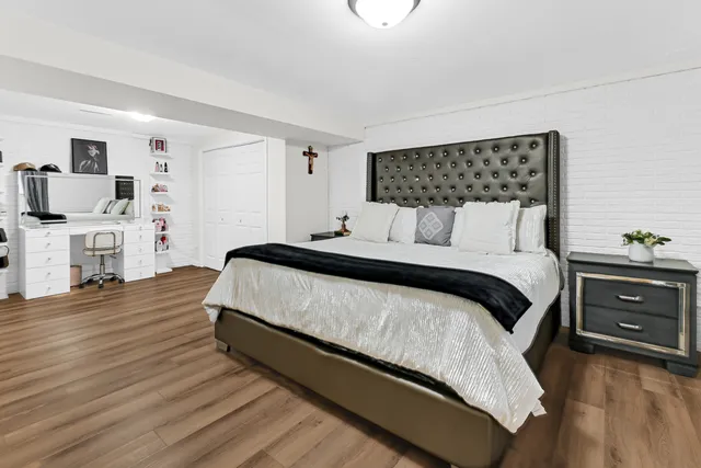 a bedroom with a bed and wooden floor