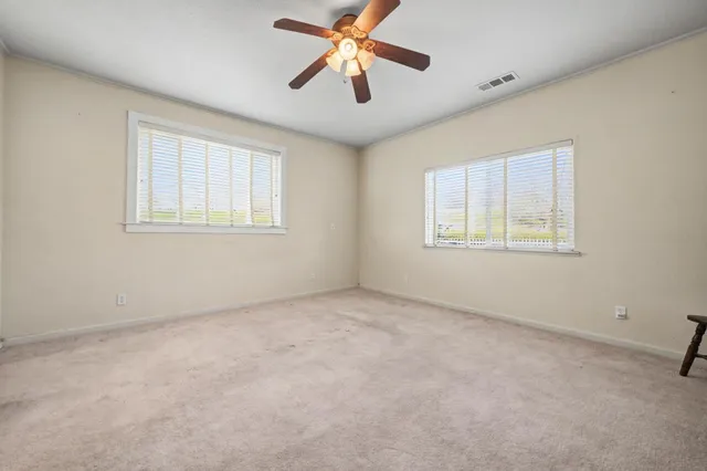 a view of a livingroom with a fireplace and a chandelier fan