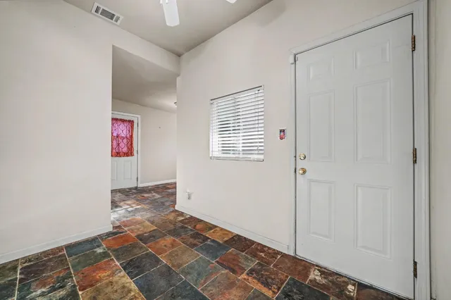 a view of an empty room with window and closet