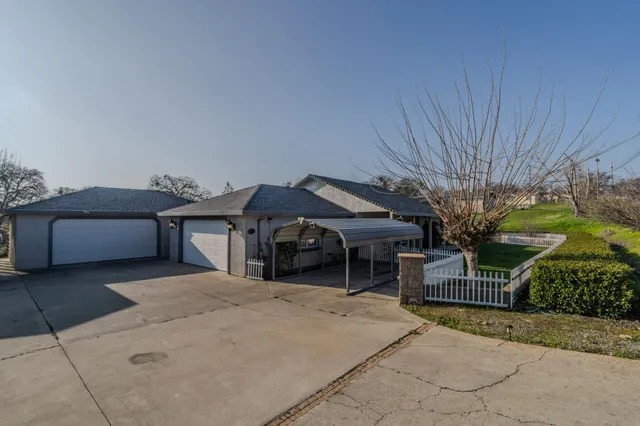 a view of a house with a backyard and a tree