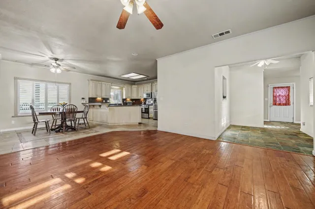 a view of a livingroom with furniture a ceiling fan and kitchen view