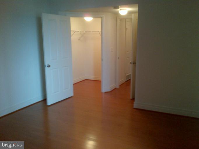 414 Water Street, Unit 1901 Baltimore, MD 21202 - Photo 4 of 17 Guest Bedroom with Hardwood & W/I Closet