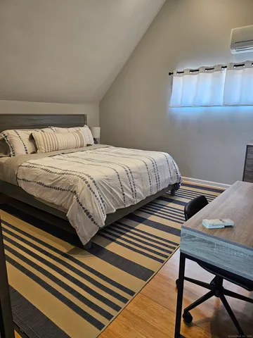 a bedroom with bed and wooden floor
