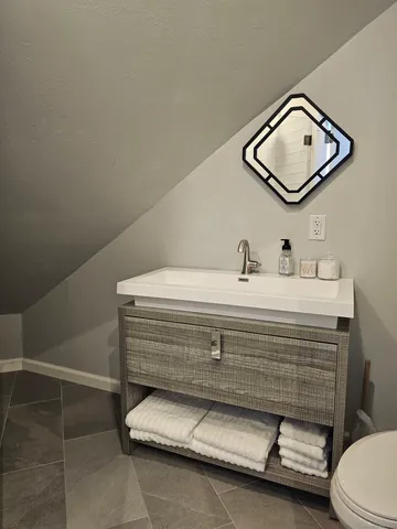 a bathroom with a sink a toilet and mirror