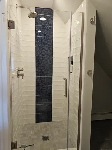 a bathroom with a shower and a glass door shower