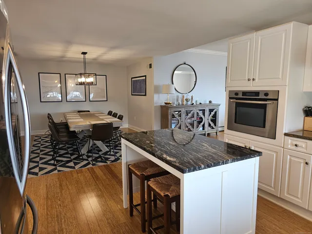 a view of a dining room kitchen with furniture a fireplace and wooden floor