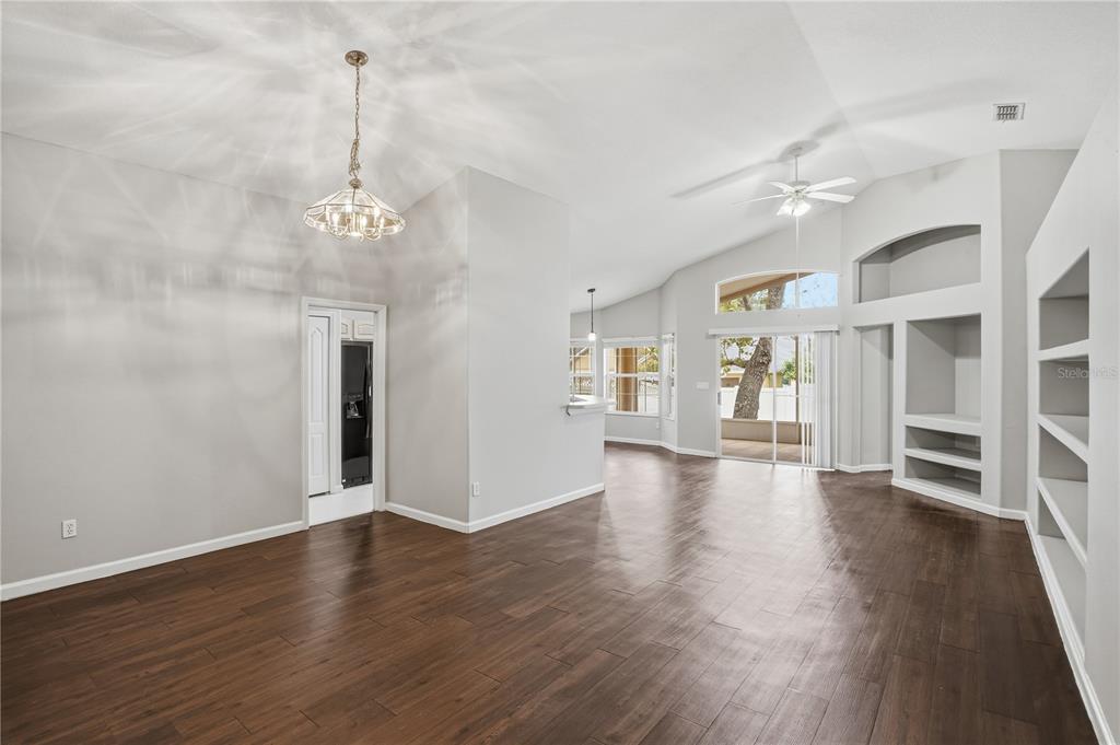 2834 Mayflower Loop Clermont, FL 34714 - Photo 8 of 28 a view of an empty room with wooden floor and a window