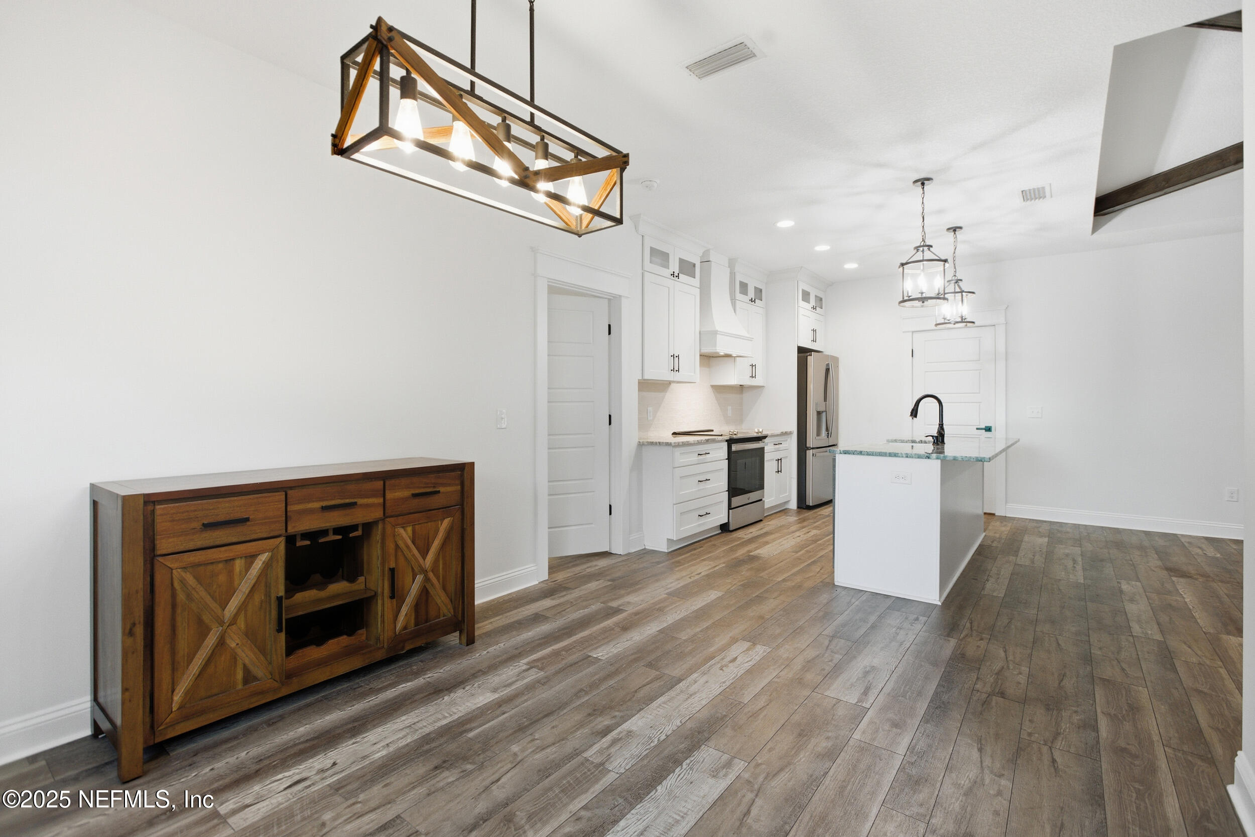 128 Santa Rosa Street Florahome, FL 32140 - Photo 25 of 57 a view of a kitchen with a sink a refrigerator and wooden floor