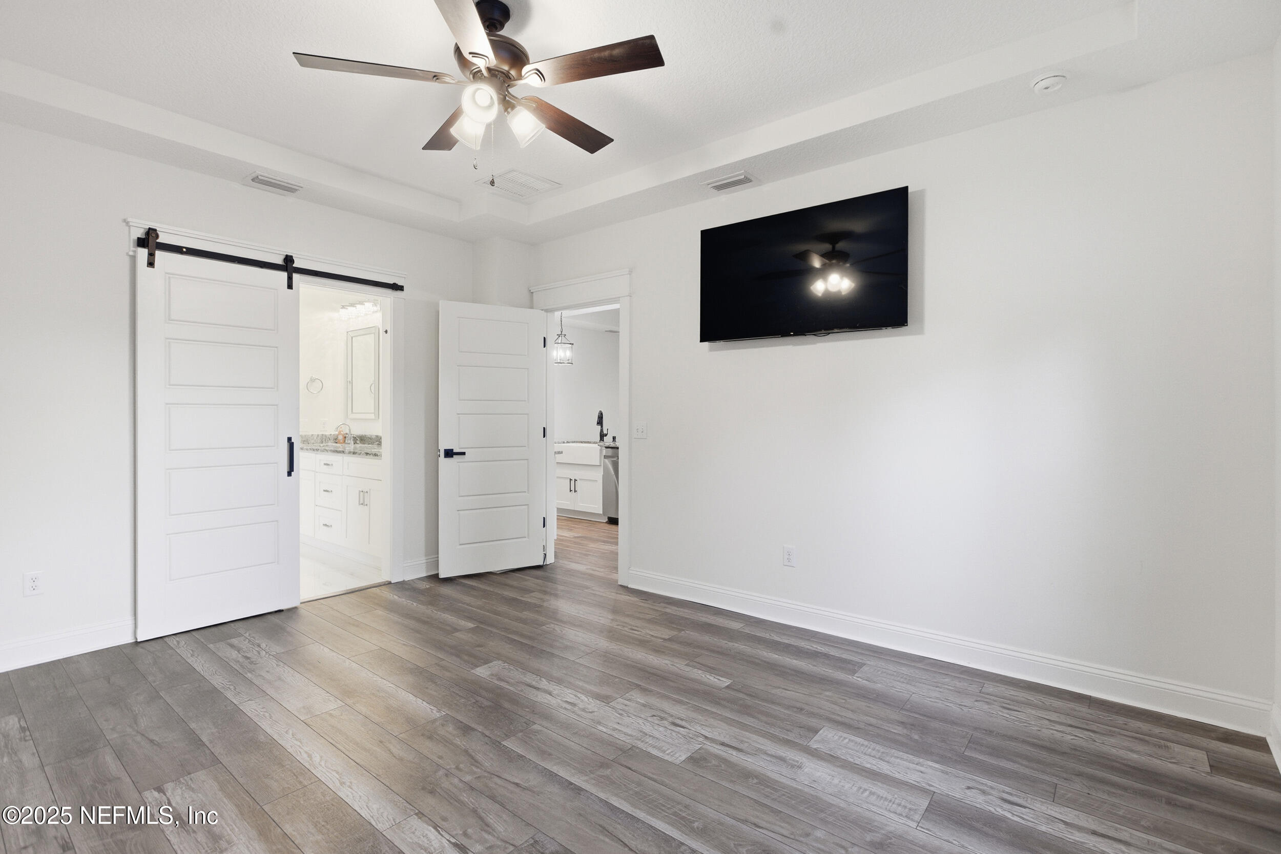 128 Santa Rosa Street Florahome, FL 32140 - Photo 26 of 57 a view of an empty room with wooden floor and a ceiling fan