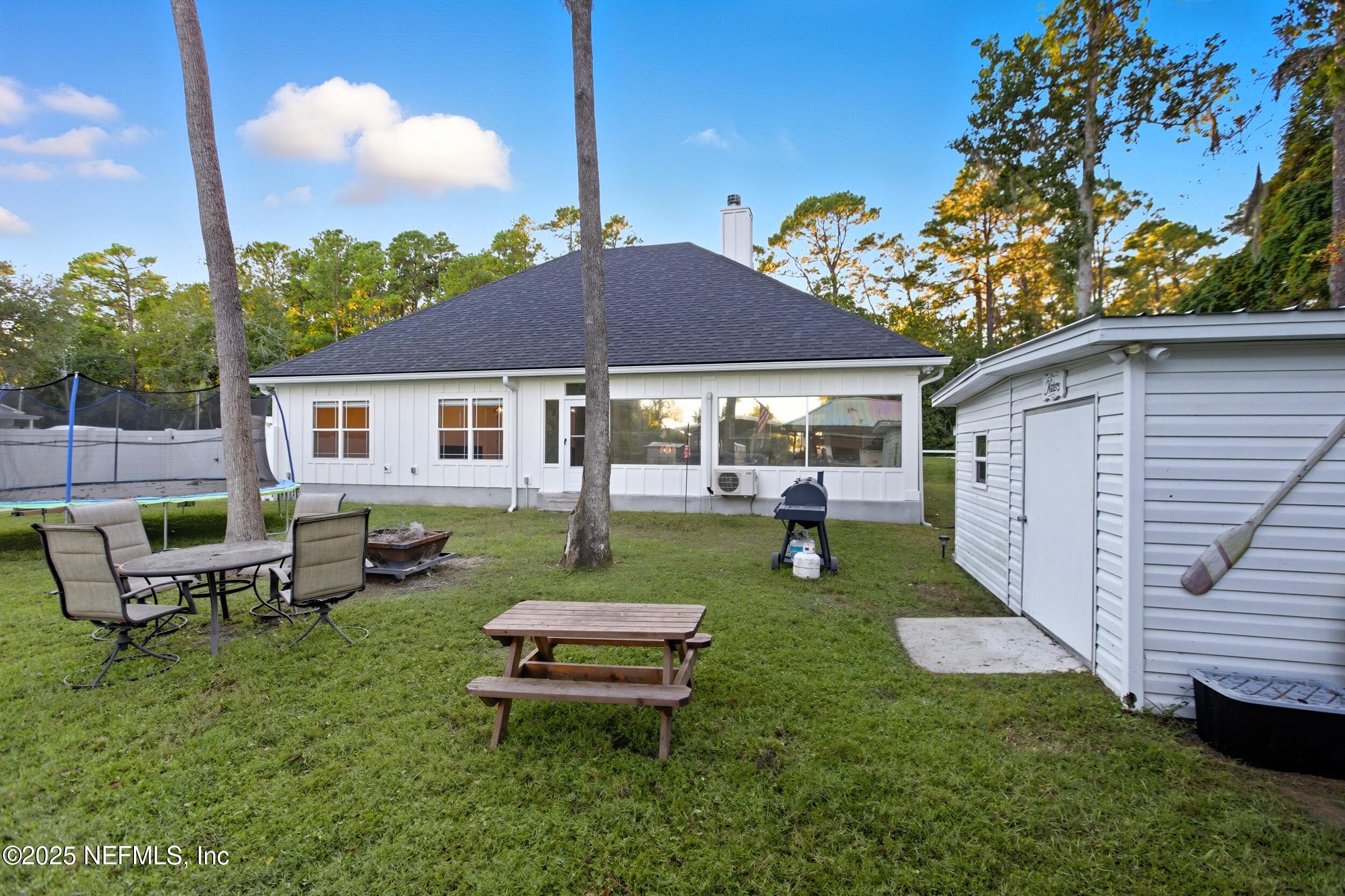 128 Santa Rosa Street Florahome, FL 32140 - Photo 38 of 57 a view of a backyard with table and chairs under an umbrella