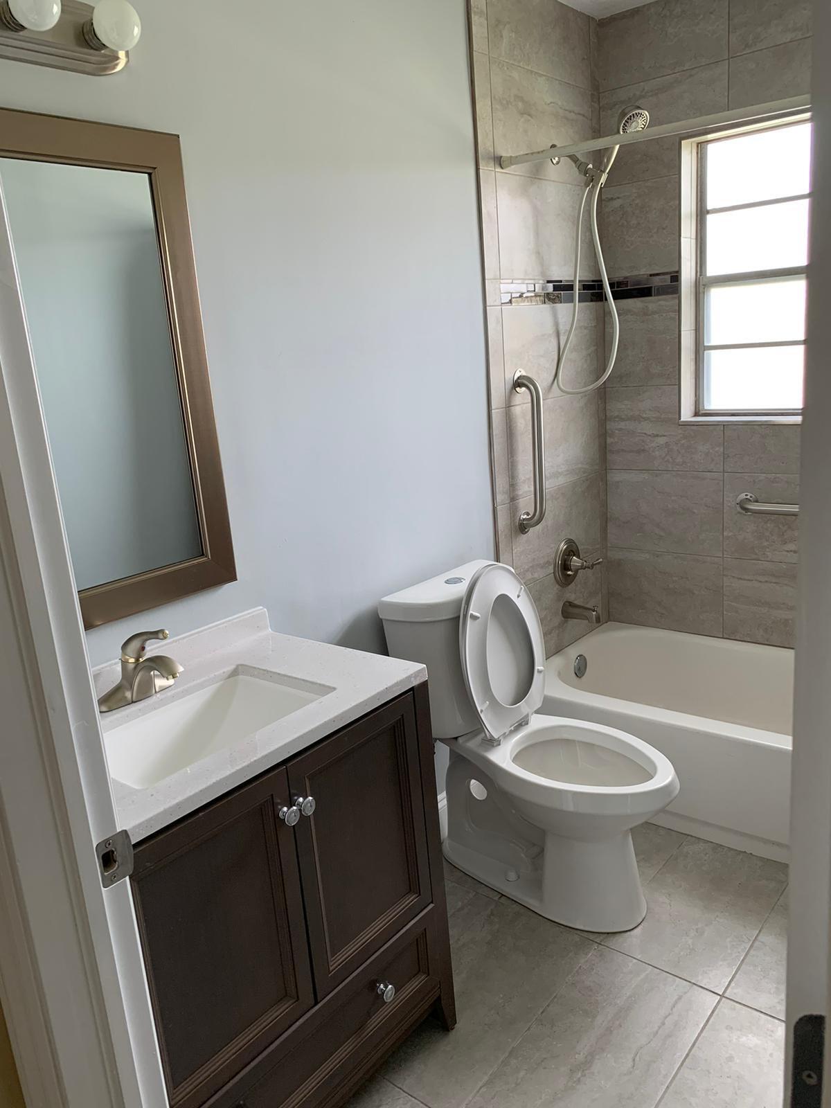 523 Colonial Road, Unit A B West Palm Beach, FL 33405 - Photo 4 of 11 a bathroom with a granite countertop sink toilet and a mirror
