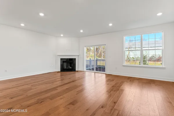 an empty room with wooden floor and fireplace