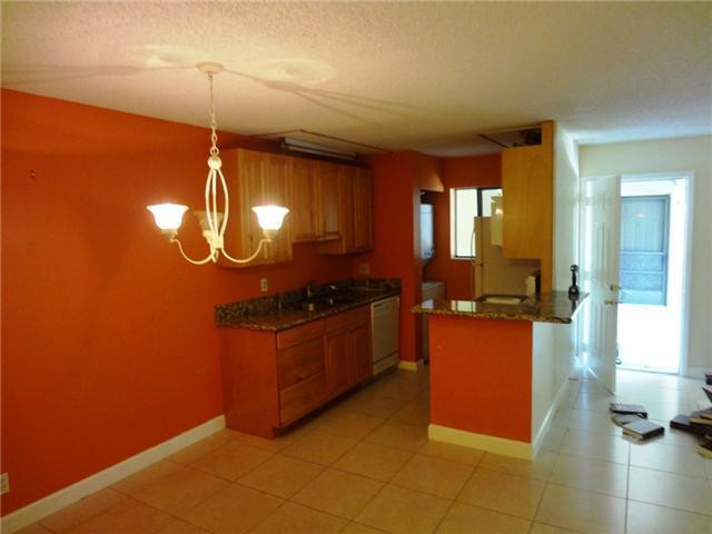 567 Trace Circle, Unit 110 Deerfield Beach, FL 33441 - Photo 6 of 8 a kitchen with stainless steel appliances granite countertop a sink a stove top oven a counter space and cabinets