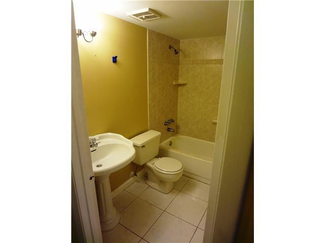 567 Trace Circle, Unit 110 Deerfield Beach, FL 33441 - Photo 7 of 8 a bathroom with a granite countertop sink toilet and shower