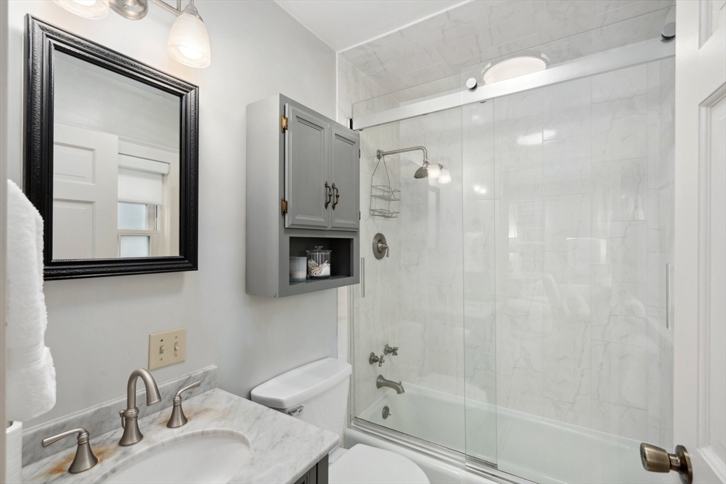 12 Cherry Lane Dedham, MA 02026 - Photo 18 of 37 a bathroom with a shower a mirror and a sink