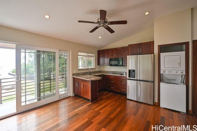 a kitchen with stainless steel appliances granite countertop a refrigerator a stove a sink dishwasher and a oven with wooden floor