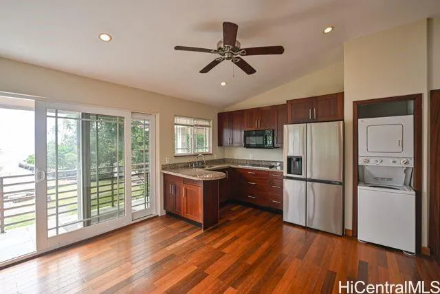 a kitchen with stainless steel appliances granite countertop a refrigerator a stove a sink dishwasher and a oven with wooden floor