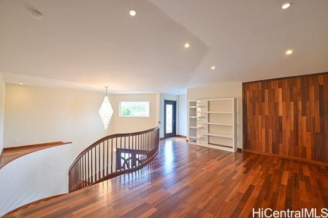 a view of a hallway with wooden floor and windows