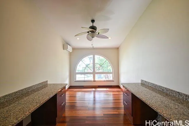 an empty room with a chandelier fan and windows