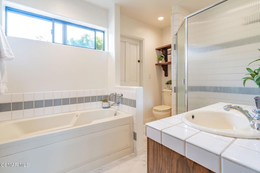 6078 Peppertree Lane Simi Valley, CA 93063 - Photo 38 of 59 a bathroom with a tub a sink and a large mirror