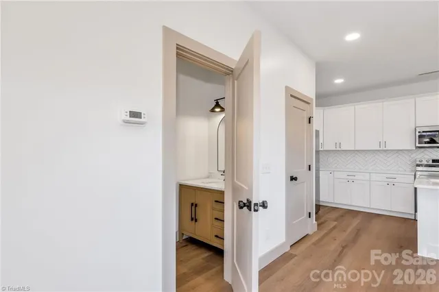 a view of a kitchen with white cabinets and wooden floor