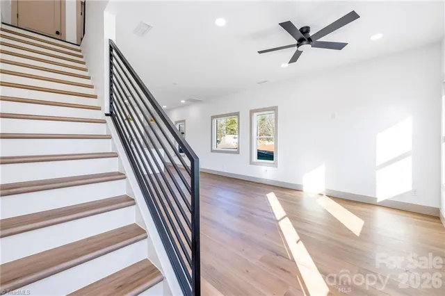 a view of a hallway with wooden floor and windows