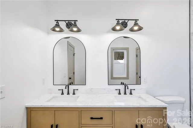 a bathroom with double vanity sinks and two mirror