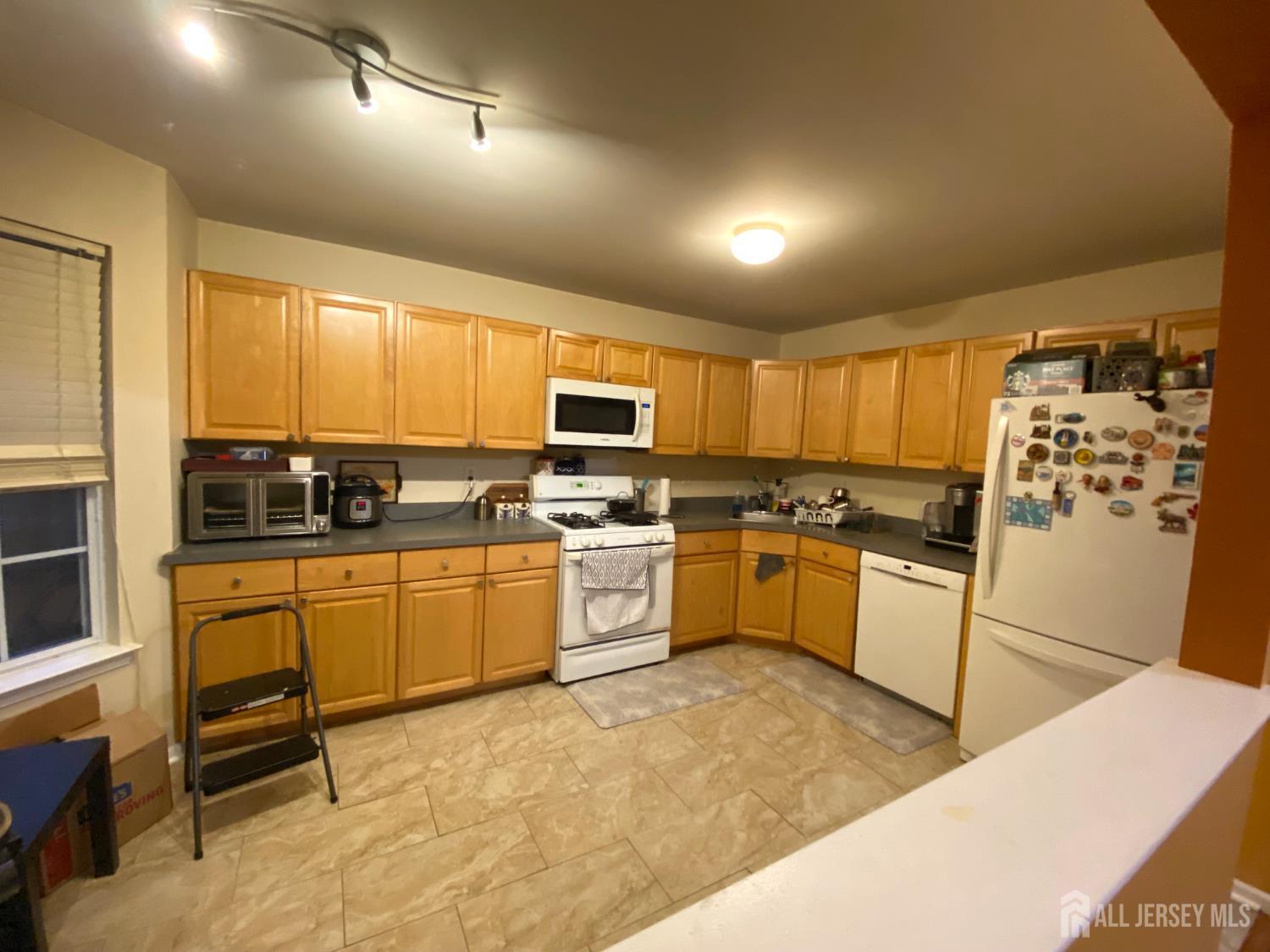 228 Hawthorne Road North Brunswick, NJ 08902 - Photo 7 of 23 a kitchen with stainless steel appliances granite countertop a stove a sink a refrigerator with white cabinets and wooden floor